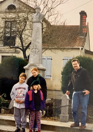 Jeff, Jillian, Scott, and Audrey Vitter in December 1998 at Uzan, France monument to the war dead of WWI.  The monument bears an inscription to
                its funders: the St. Raymond, Ferran, and Cougot families